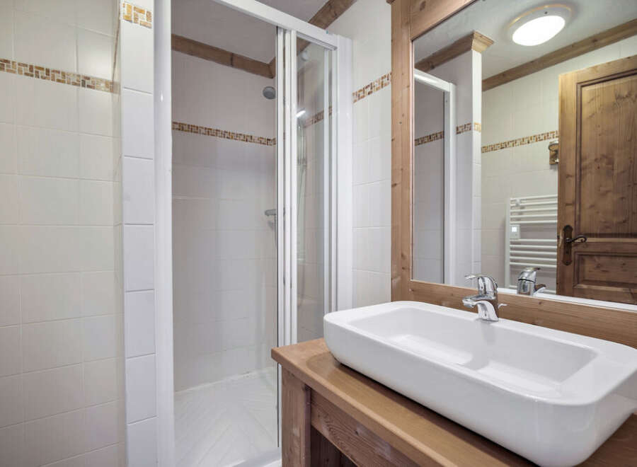 This charming bathroom features a modern design with a sleek, rectangular sink set atop a wooden vanity.