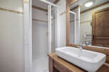 This charming bathroom features a modern design with a sleek, rectangular sink set atop a wooden vanity.