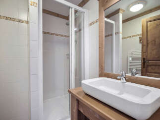 This charming bathroom features a modern design with a sleek, rectangular sink set atop a wooden vanity.
