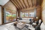Experience the warmth of this stunning chalet-style living room, featuring beautiful wooden walls and ceilings.