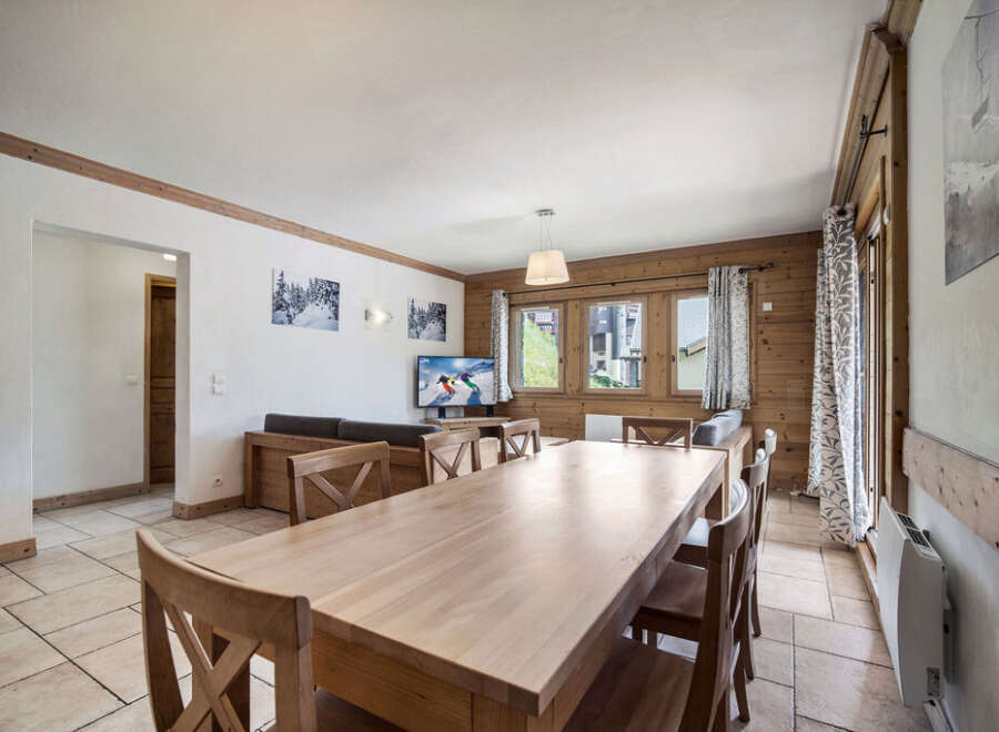 This charming property features a spacious dining area with a large wooden table, perfect for gatherings.