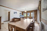 This charming property features a spacious dining area with a large wooden table, perfect for gatherings.