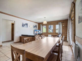 This charming property features a spacious dining area with a large wooden table, perfect for gatherings.