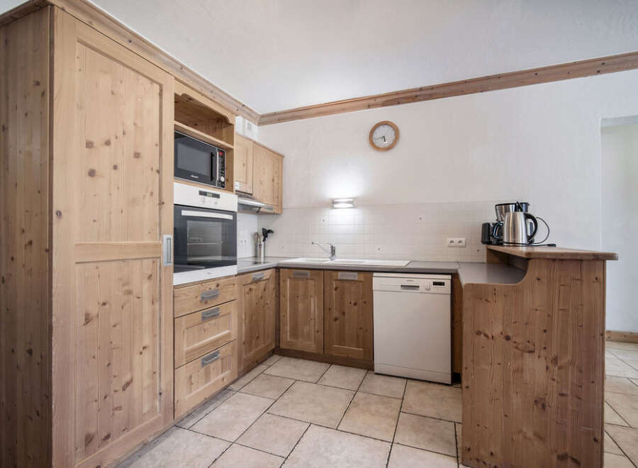 This charming kitchen boasts beautiful wooden cabinetry and a modern design.