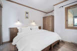 This cozy bedroom features a comfortable bed with crisp white linens, perfect for a relaxing retreat.