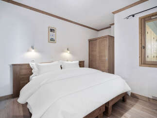 This cozy bedroom features a comfortable bed with crisp white linens, perfect for a relaxing retreat.