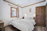 This cozy bedroom features a comfortable bed with crisp white linens, perfect for a relaxing retreat.