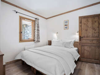This cozy bedroom features a comfortable bed with crisp white linens, perfect for a relaxing retreat.