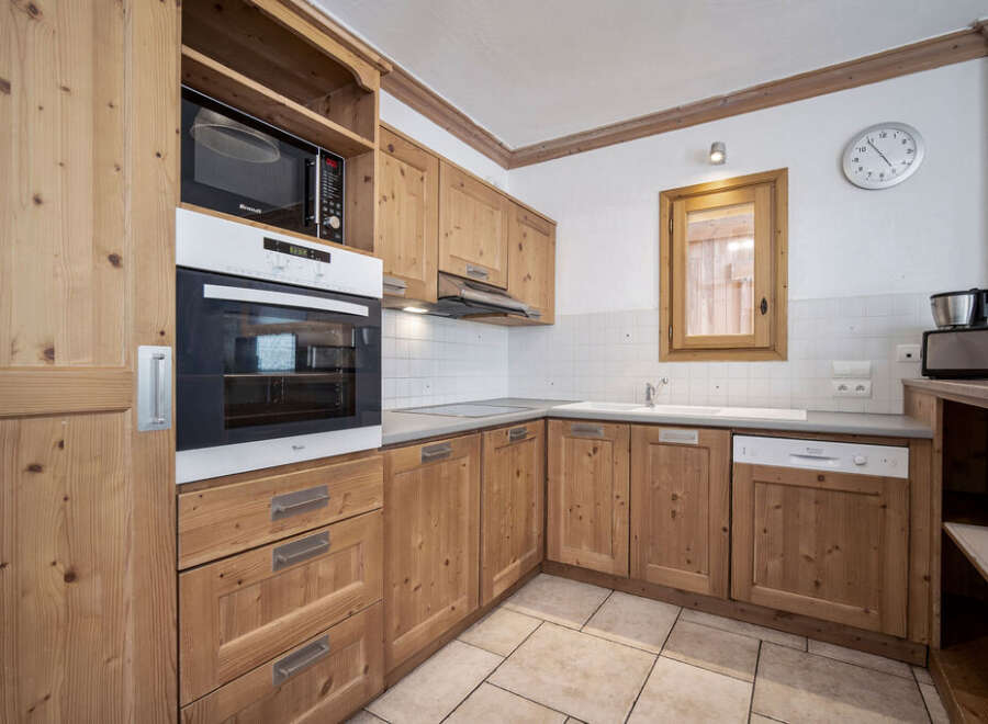 This charming kitchen features warm wooden cabinetry, creating a cozy and inviting atmosphere.