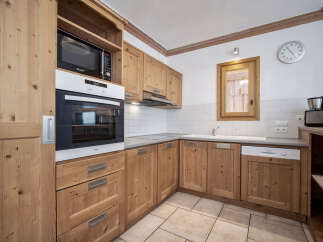 This charming kitchen features warm wooden cabinetry, creating a cozy and inviting atmosphere.