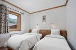 This cozy bedroom features two twin beds with crisp white linens, perfect for a comfortable stay.