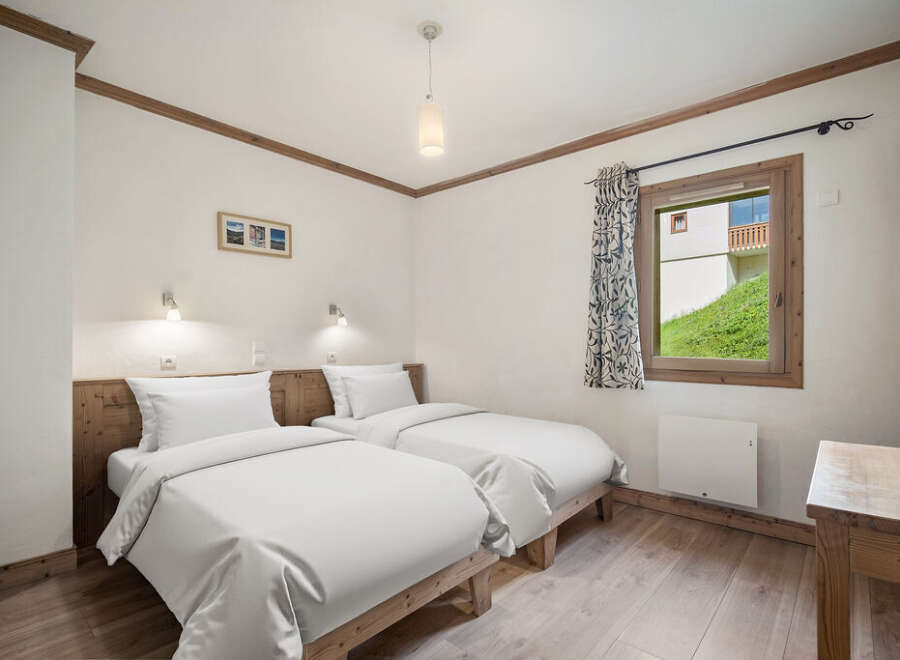 This cozy bedroom features two twin beds, perfect for guests or a comfortable stay.