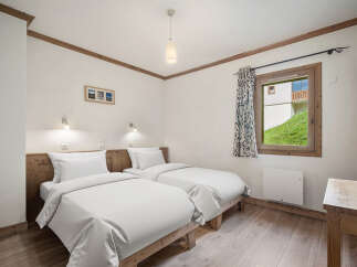 This cozy bedroom features two twin beds, perfect for guests or a comfortable stay.