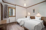 This cozy bedroom features two twin beds with crisp white linens, perfect for a comfortable stay.