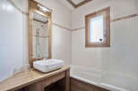 This charming bathroom features a rustic wooden vanity and mirror frame, creating a warm and inviting atmosphere.
