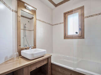 This charming bathroom features a rustic wooden vanity and mirror frame, creating a warm and inviting atmosphere.