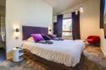 Experience luxury in this stunning bedroom! Featuring a plush bed with vibrant purple accents, this space is designed for ultimate comfort.