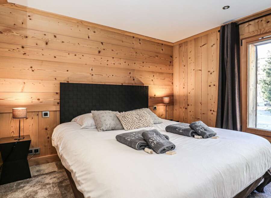 Experience the warmth of this cozy bedroom featuring stunning wood paneling that adds a touch of rustic elegance.