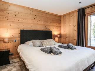 Experience the warmth of this cozy bedroom featuring stunning wood paneling that adds a touch of rustic elegance.