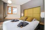 Experience luxury in this stunning bedroom featuring a plush, yellow headboard and a comfortable bed.