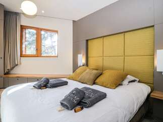 Experience luxury in this stunning bedroom featuring a plush, yellow headboard and a comfortable bed.