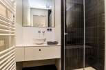 This modern bathroom features a sleek design with a white vanity and a stylish vessel sink.