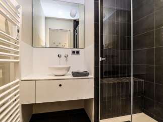 This modern bathroom features a sleek design with a white vanity and a stylish vessel sink.