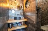This stunning bathroom boasts a unique design with a sleek black sink and stylish lighting fixtures.