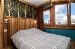 Experience the charm of this cozy bedroom featuring a unique wooden accent wall and a stylish bedspread.