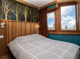 Experience the charm of this cozy bedroom featuring a unique wooden accent wall and a stylish bedspread.