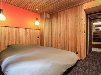 This cozy bedroom features a unique wooden paneling design, creating a warm and inviting atmosphere.