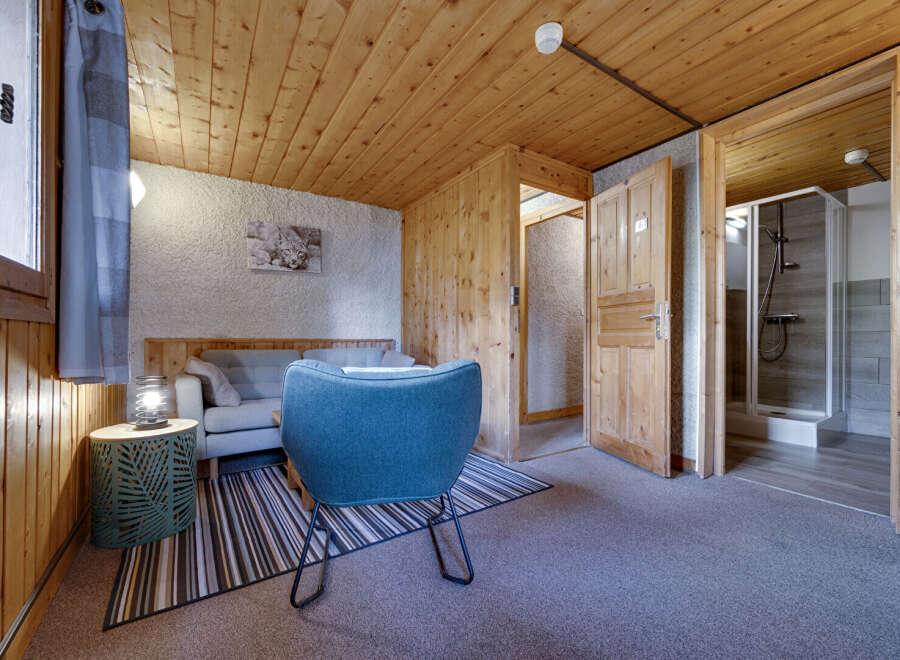 Discover the charm of this cozy property, featuring a beautifully designed living space with wooden accents and a comfortable seating area.
