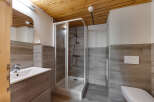 This stunning bathroom features a modern design with wood-look tile and a sleek glass shower enclosure.
