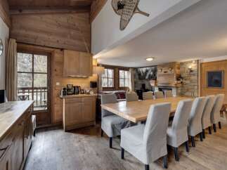 Experience the charm of this stunning property, featuring a spacious dining area with a large wooden table and comfortable seating.
