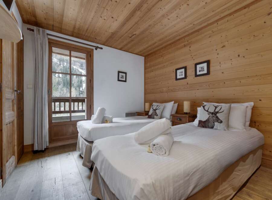 This cozy bedroom features two comfortable beds with decorative pillows and crisp white linens.