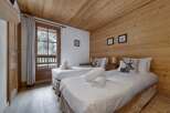 This cozy bedroom features two comfortable beds with decorative pillows and crisp white linens.