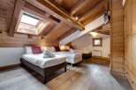 Discover the charm of this stunning bedroom, featuring a unique sloped ceiling and exposed wooden beams that add character and warmth.