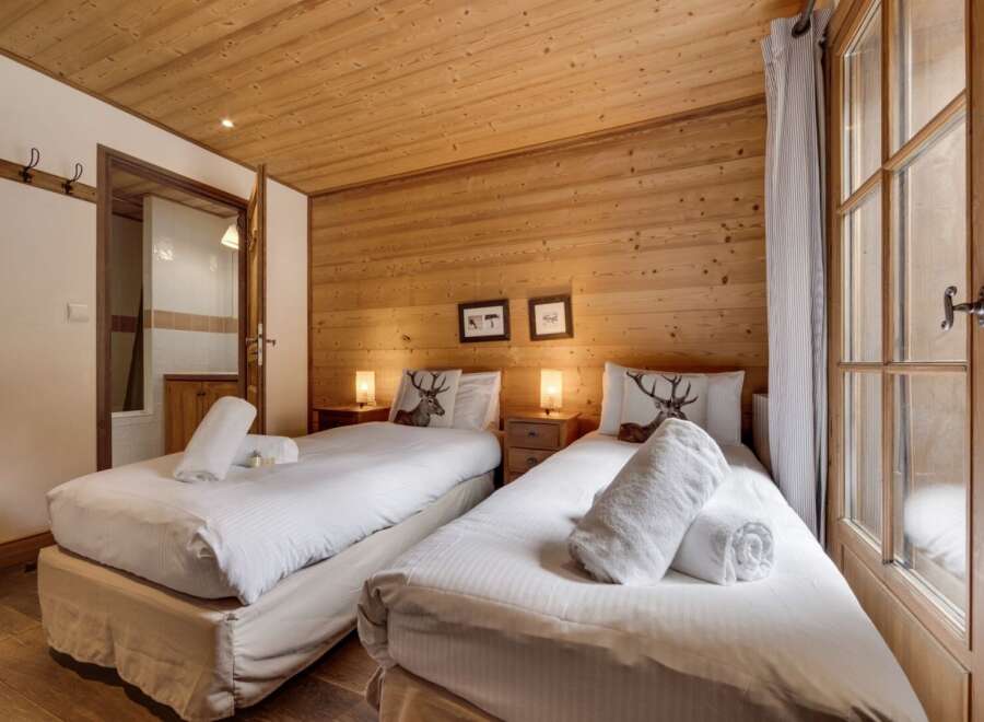 Experience the cozy charm of this inviting bedroom, featuring warm wooden accents and comfortable twin beds.