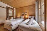 Experience the cozy charm of this inviting bedroom, featuring warm wooden accents and comfortable twin beds.
