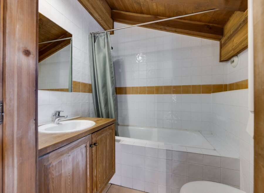 This charming bathroom features a unique design with wooden accents and a cozy atmosphere.