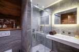 Step into luxury with this stunning bathroom featuring a modern glass shower and sleek white sink.