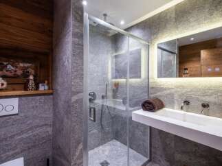 Step into luxury with this stunning bathroom featuring a modern glass shower and sleek white sink.
