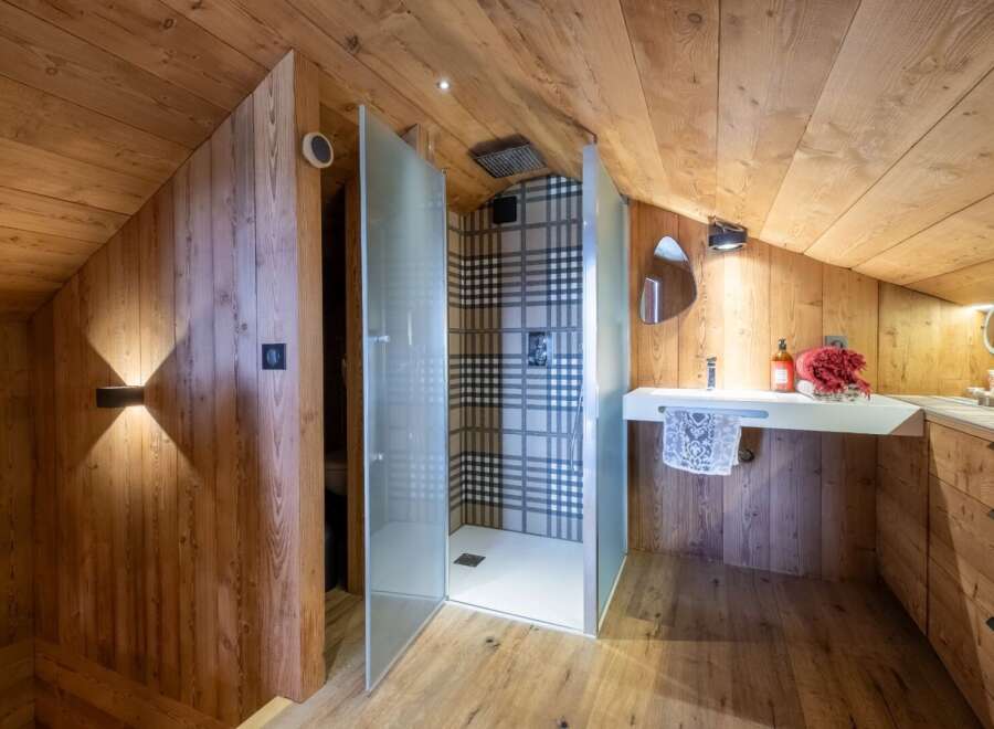 This stunning bathroom boasts a unique design with wooden walls and ceiling, creating a warm and inviting atmosphere.