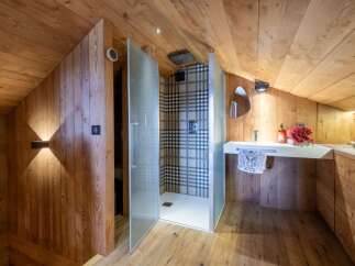 This stunning bathroom boasts a unique design with wooden walls and ceiling, creating a warm and inviting atmosphere.