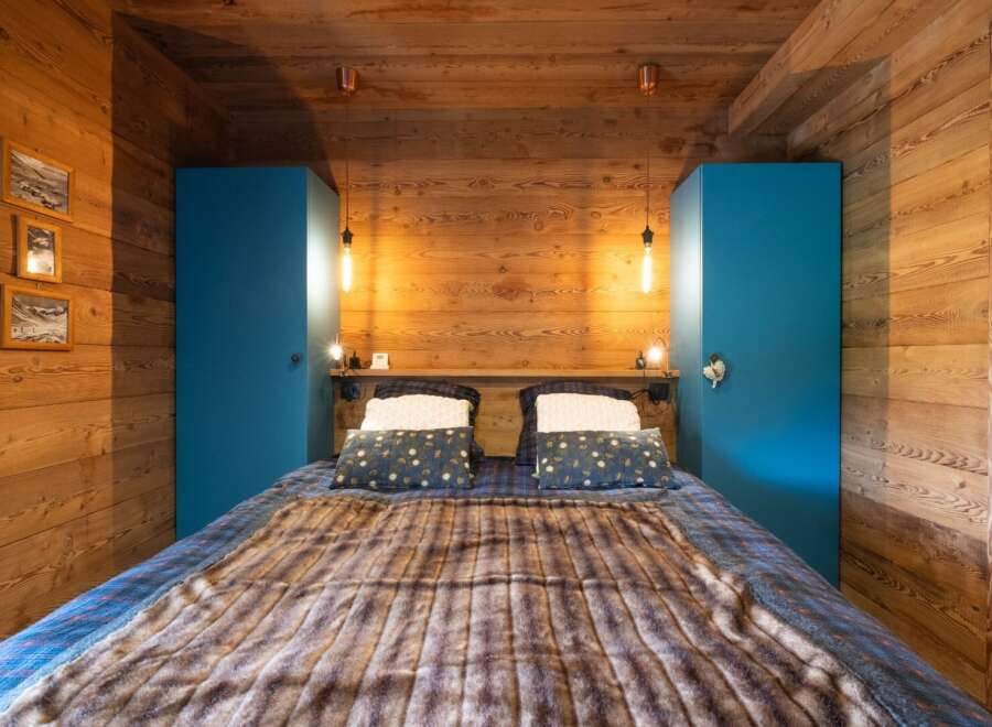 This cozy bedroom features a rustic wooden design with a warm and inviting atmosphere.