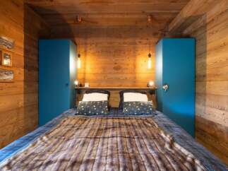 This cozy bedroom features a rustic wooden design with a warm and inviting atmosphere.