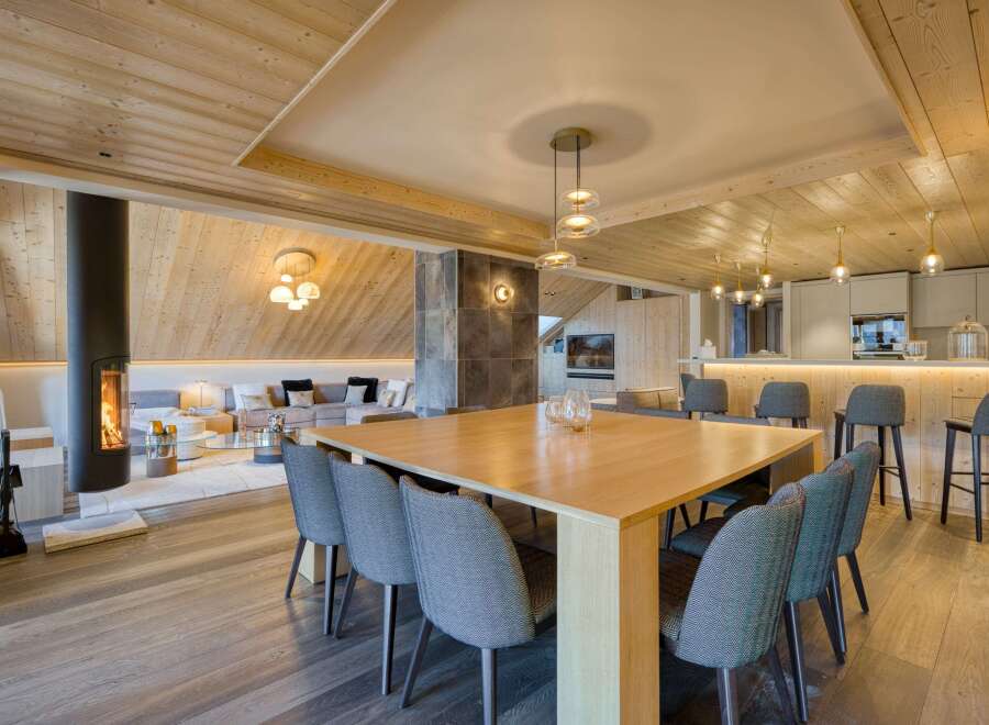 Experience luxury living in this stunning property featuring a modern dining area with a sleek wooden table and stylish chairs.