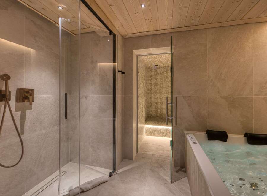 Indulge in luxury with this spa-like bathroom featuring a sleek glass shower and a rejuvenating jacuzzi tub.