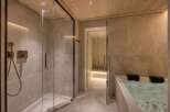 Indulge in luxury with this spa-like bathroom featuring a sleek glass shower and a rejuvenating jacuzzi tub.