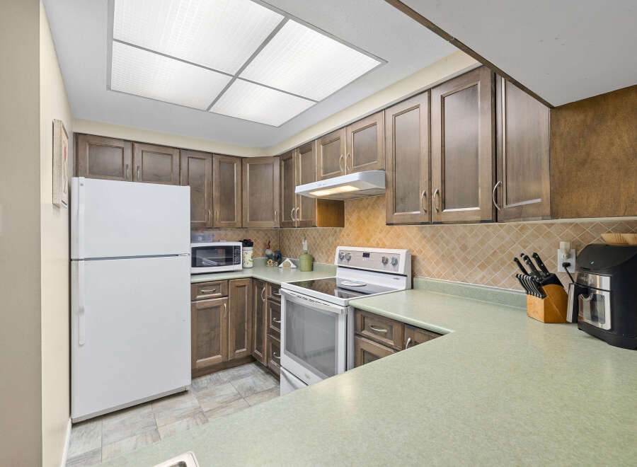 This charming kitchen boasts ample cabinet space and a functional layout, perfect for culinary enthusiasts.